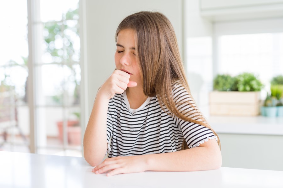 Obraz przedstawia dziecko kaszlące, co może sugerować objawy kaszlu krtaniowego.